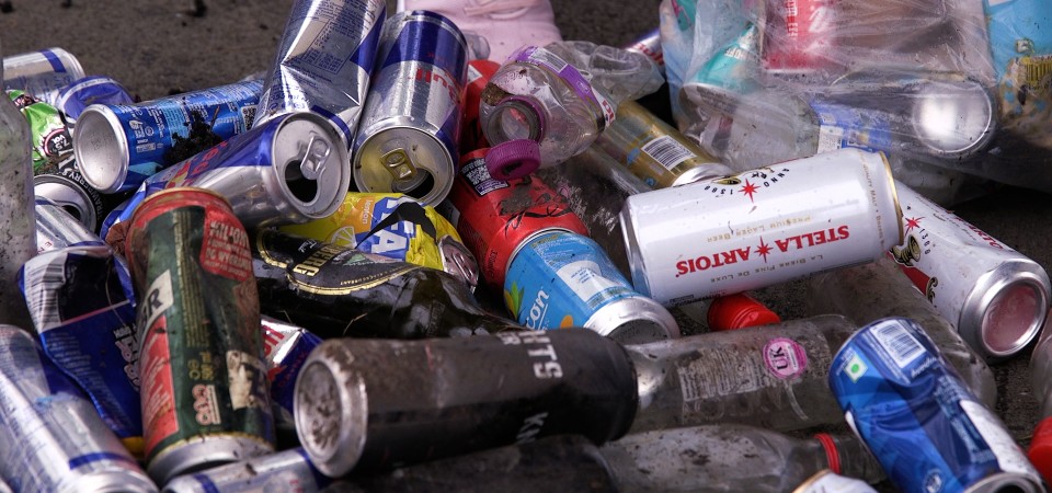 Lots of cans and litter strewn haphazardly upon the floor