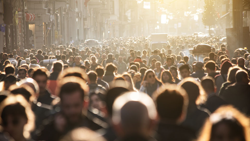 A crowd of people walking on a blurred street