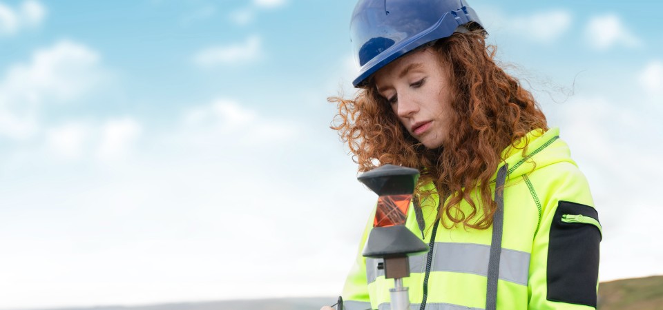 A young apprentice studies surveying equipment