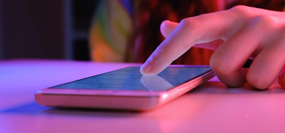 A young person scrolling on a mobile phone