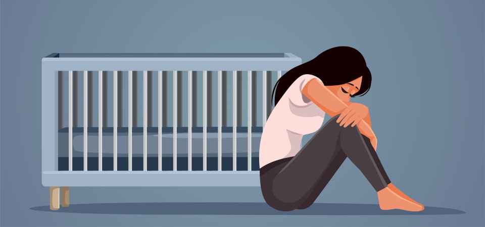 Woman sitting next to an empty cot