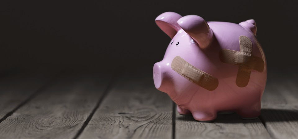 A piggy bank with plasters on it