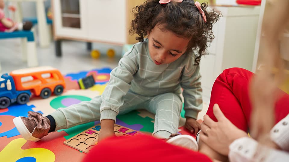 A child sat on the floor playing with toys