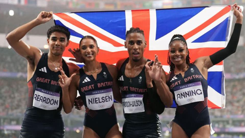 The mixed relay team pose with the Union Jack flag and wear their bronze medals
