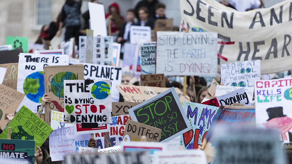 People with banners protest as part of a climate change march