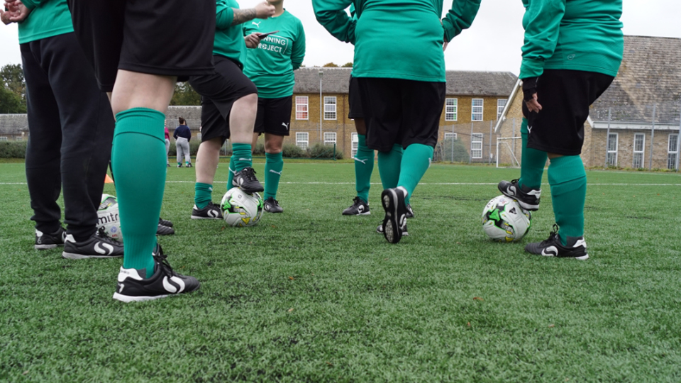 Young footballers in conversation with their coach