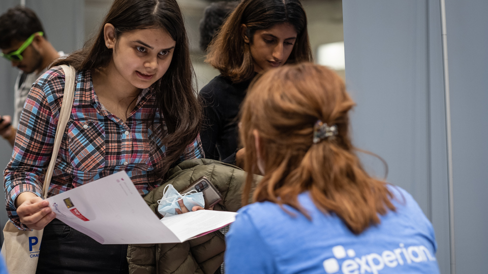 A student chatting with a potential employer at a University Careers Fair