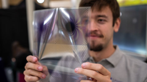 Scientist displays an acetate with moiré patterns printed on it