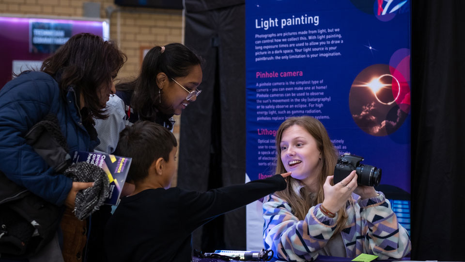 Visitors to an exhibition chatting to one of the Loughborough scientists