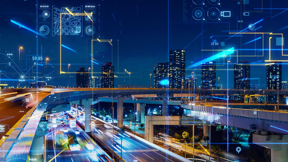 A cityscape at night, showing a busy road overlaid with icons suggesting digital connectivity