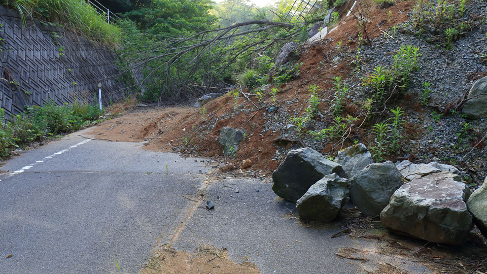 A road blocked and covered in debris following a landslide