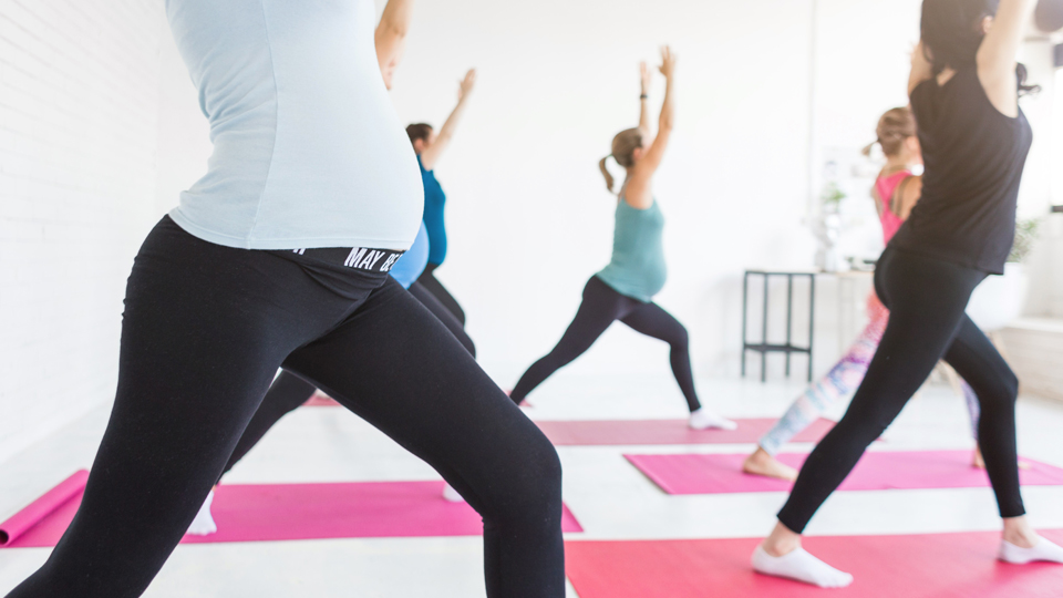 Pregnant women photographed during a yoga class