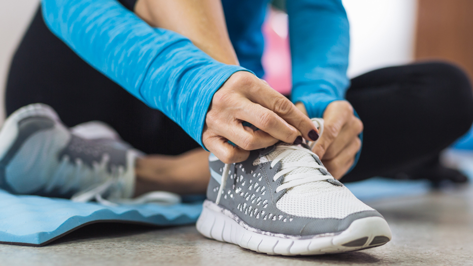 Close up of a women tying her trainer laces ahead of exercising