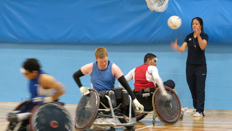 three wheelchair basketball players moving around a court
