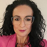 A head and shoulders picture of Jenni Johnson wearing glasses and a pink jacket
