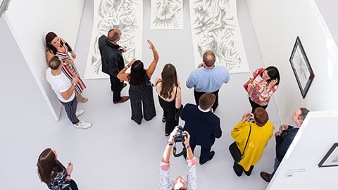 A group of people looking at a large artwork photographed from above