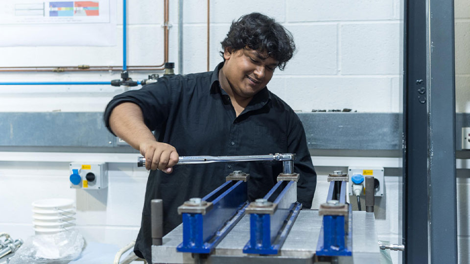 male student using a wrench