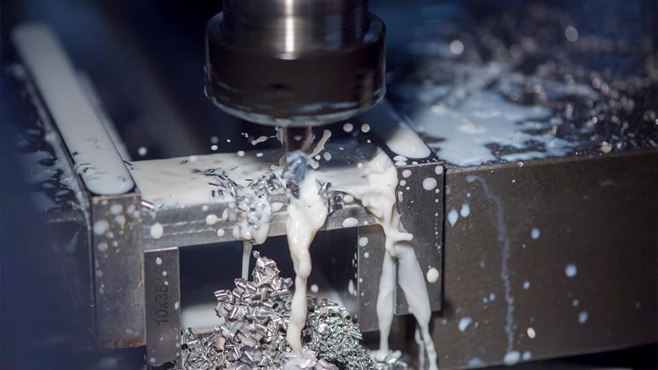 Closeup of machine with liquid and metal splashing out