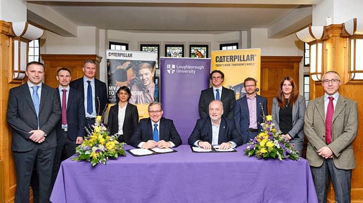 Loughborough colleagues and caterpillar sat at a table