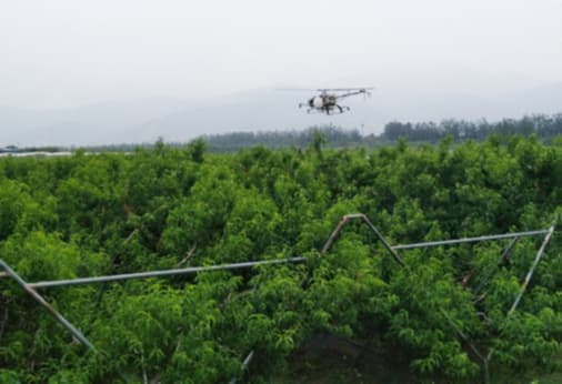 2 men in a field with a drone and tractor