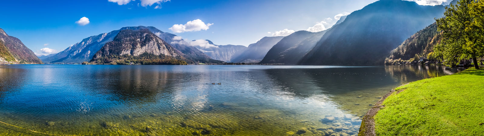 Panorama of crystal clear mountain lake in Alps.
