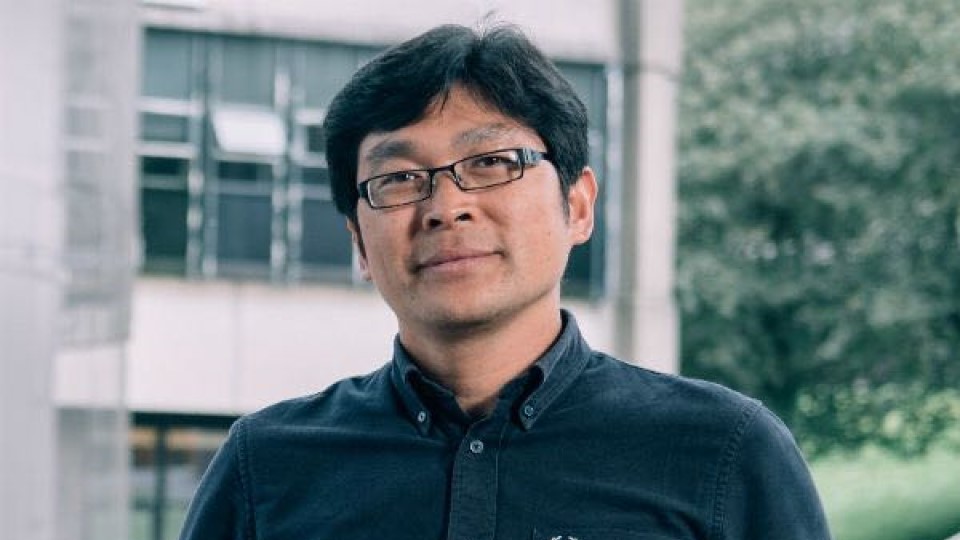 Dr Liang facing camera with a blue shirt and glasses on