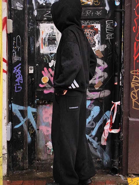 Arika Pun wearing a black tracksuit with the hood up