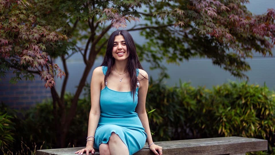 Sara Elhusseiny sitting outside on a bench.