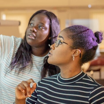 Two women looking at a whiteboard
