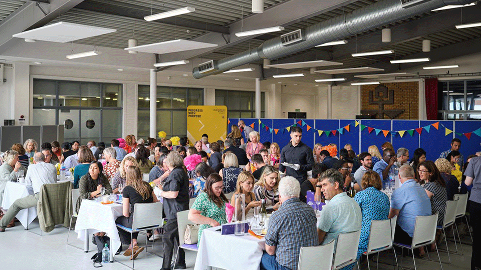 Staff seated at tables in Towers dining hall.