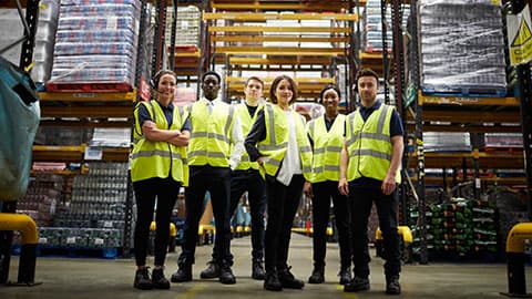 A team of staff standing together in a warehouse.