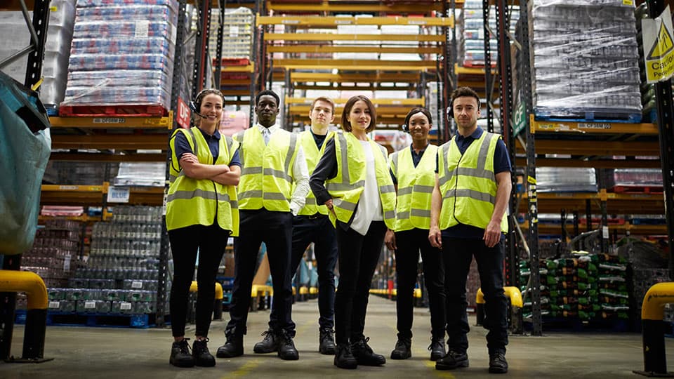 A team of staff standing together in a warehouse.