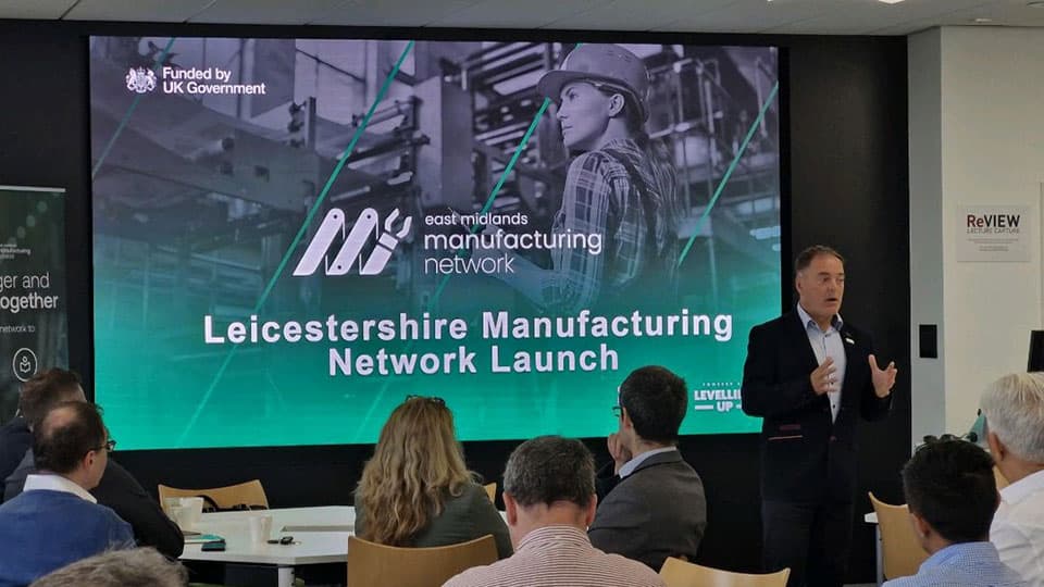 A person delivering a presentation. The screen behind them reads 'Leicestershire Manufacturing Network Launch'.