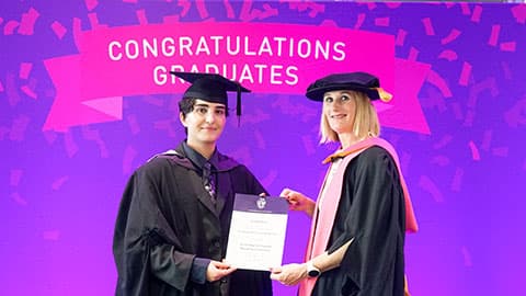 Isa Hakobyan on stage with their certificate from Professor Jan Godsell.