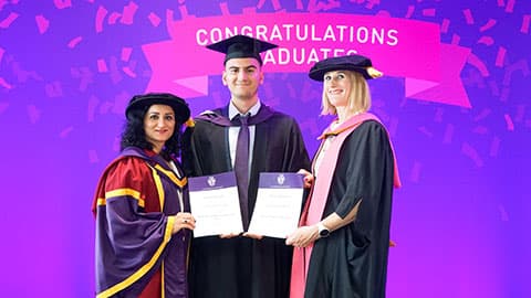 Christian Apostolov on stage with their certificate from Professor Jan Godsell and Dr Sahar Mousavi.