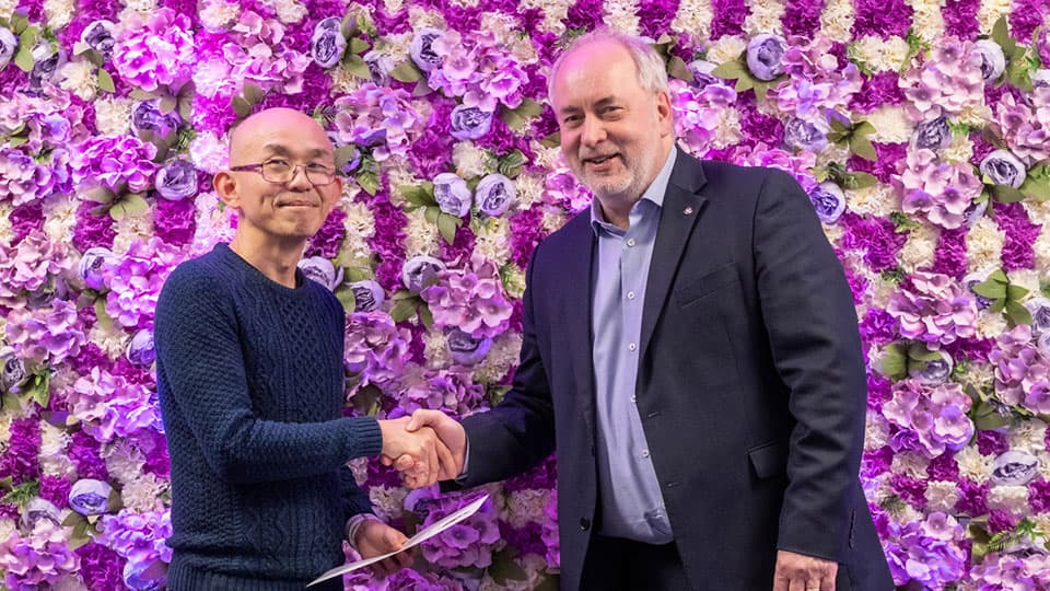 Kai-Hong Tee shaking hands with Nick Jennings.