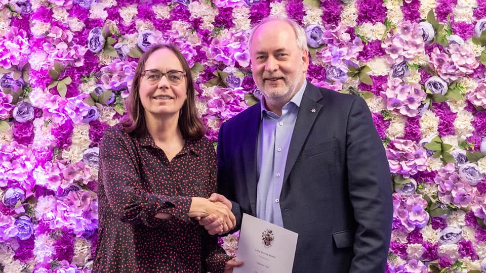 Marion Jost shaking hands with Nick Jennings.