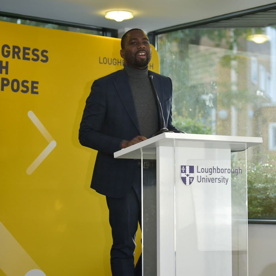 Dr Olusiji Sanya on stage giving a speech.