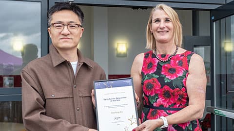 Haofeng Xu receiving an award from Jan Godsell.
