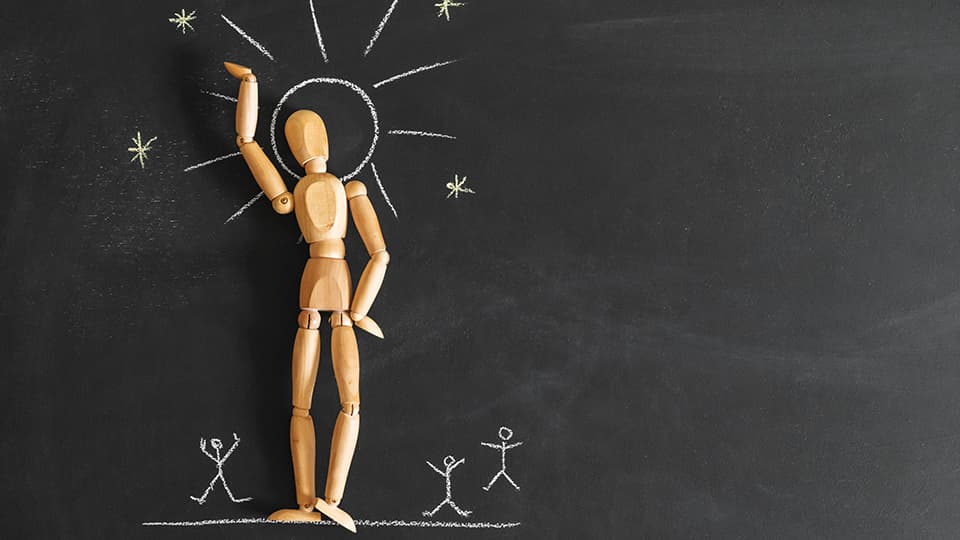 Concept of narcissism and selfishness. Wooden man on the background of chalk board.