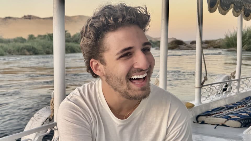 Second year Finance and Management student Alex Dillon sitting on a boat.
