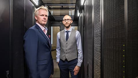 Tom Jackson and Ian Hodgkinson standing in a data centre.