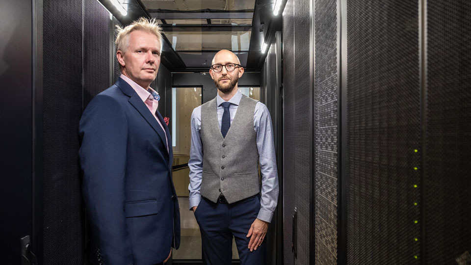 Tom Jackson and Ian Hodgkinson standing in a data centre.
