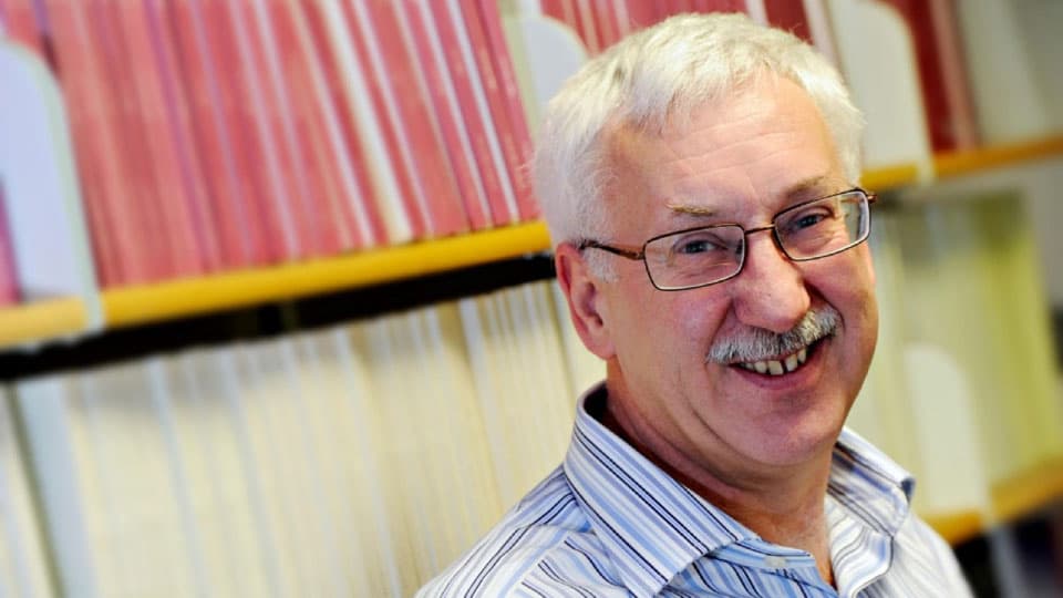 Professor Eric Pentecost standing in front of a bookshelf.