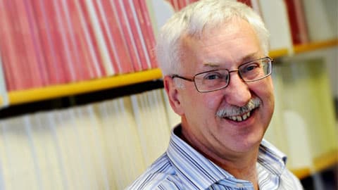 Professor Eric Pentecost standing in front of a bookshelf.