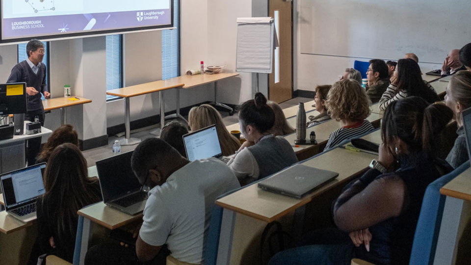 An audience in the Loughborough Business School lecture theatre listens to a talk.