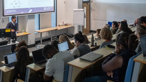 An audience in the Loughborough Business School lecture theatre listens to a talk.