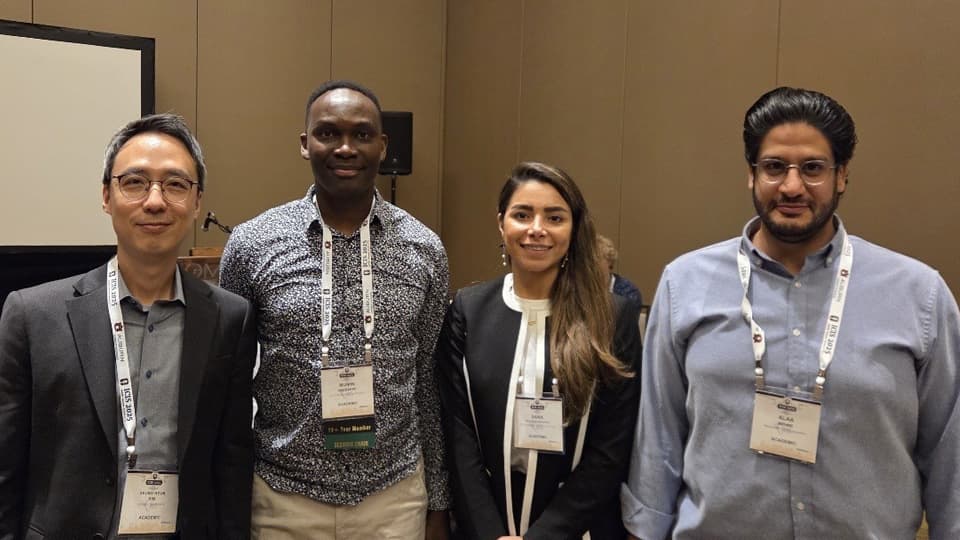 Dr Mumin Abubakre stands in a group with colleagues at ICIS 2025.