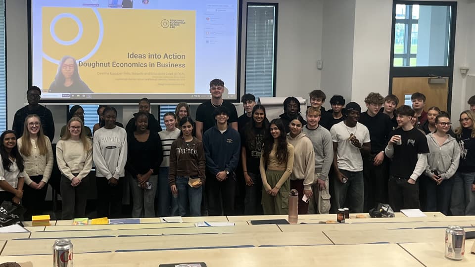 A group of students standing at the front of a lecture room.
