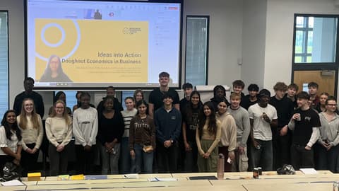 A group of students standing at the front of a lecture room.